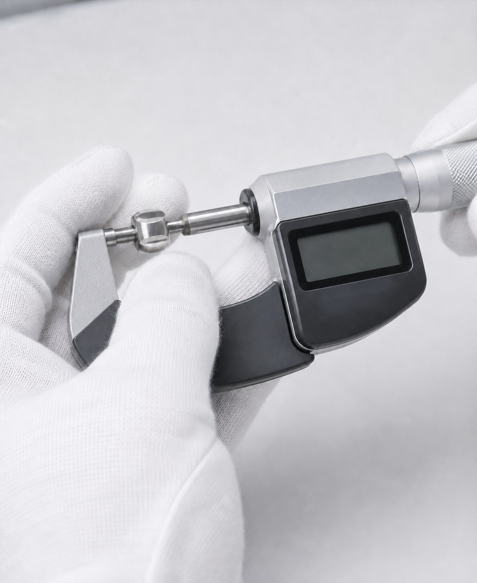 Gloved hand measuring a part with a micrometer